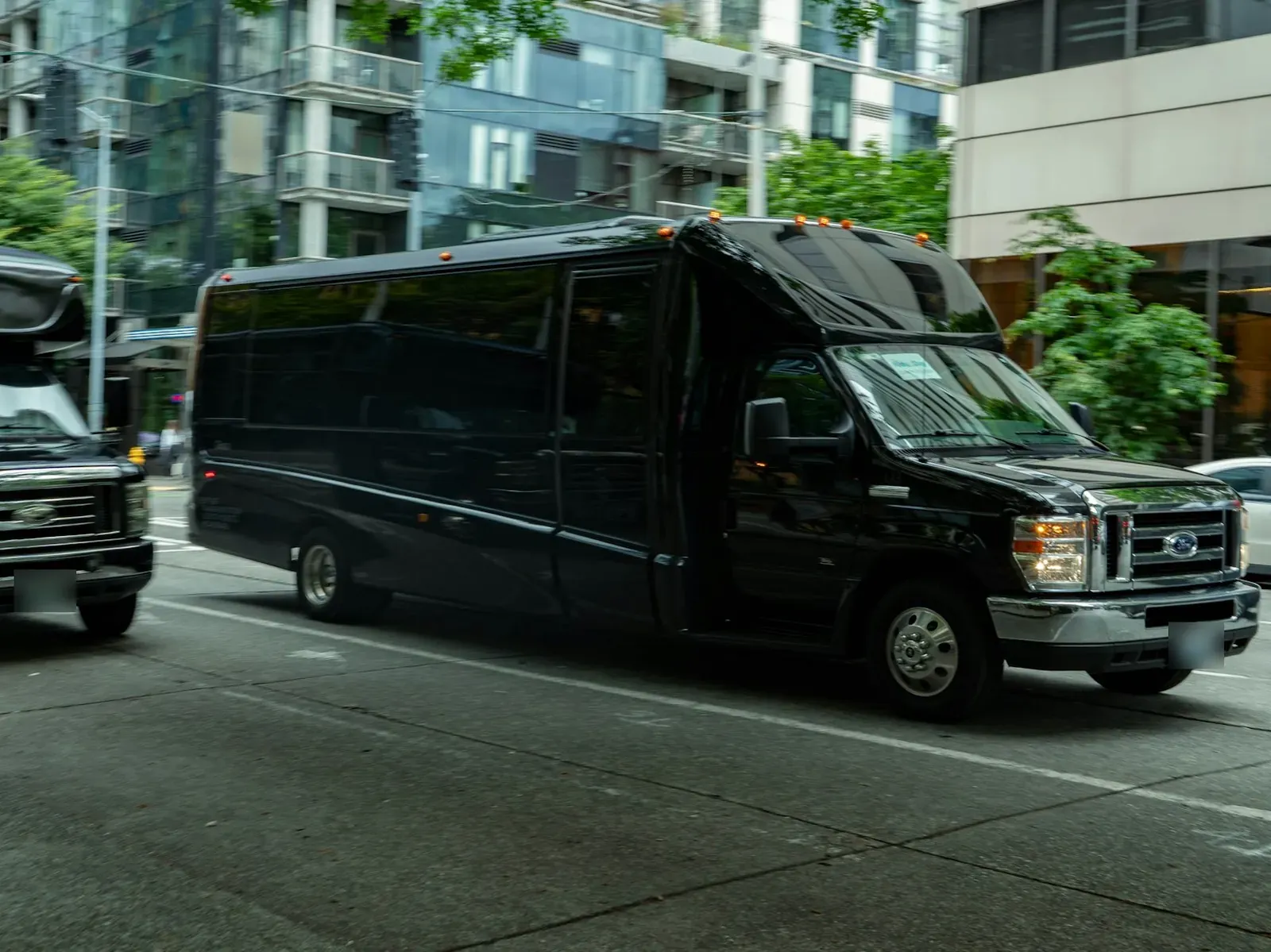 A black luxury shuttle bus on a city street